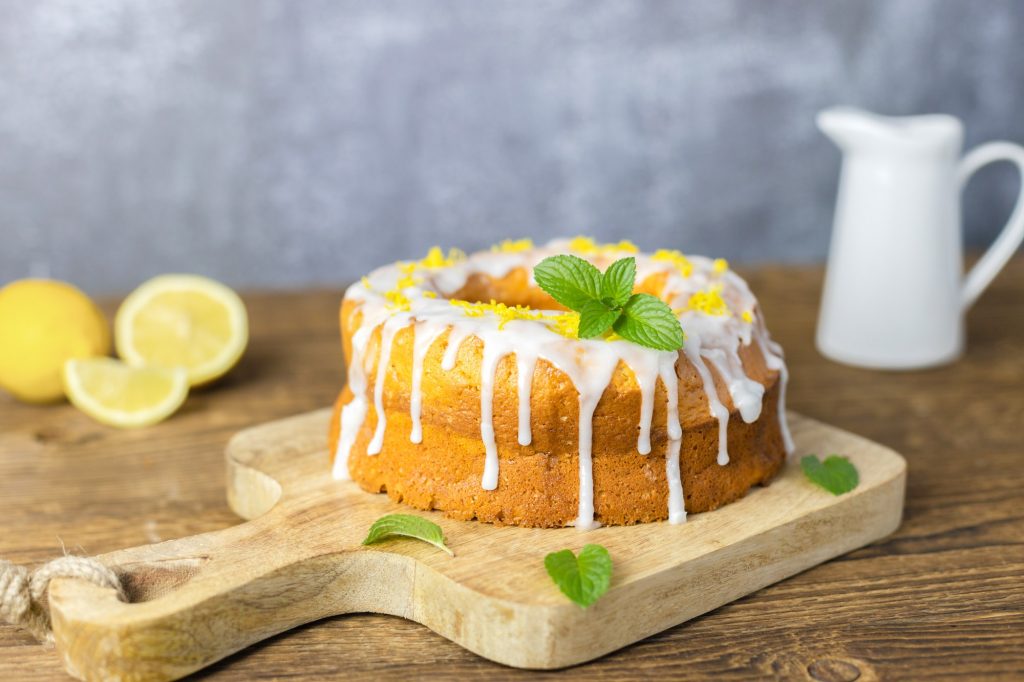 Classic lemon loaf cake, garnished with frosting and lemon shavings. Fast and tasty dessert.